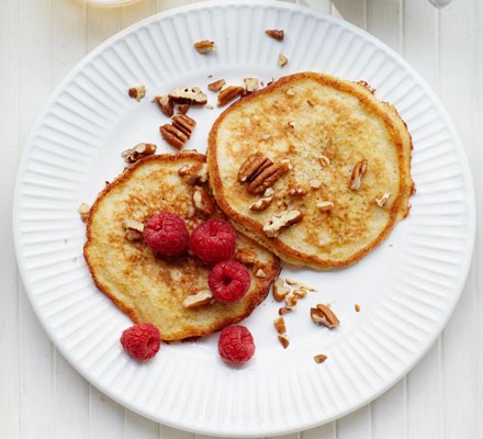 Banana pancakes sprinkled with chopped pecans and raspberries