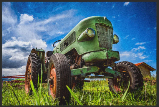 A green tractor in a field Description automatically generated