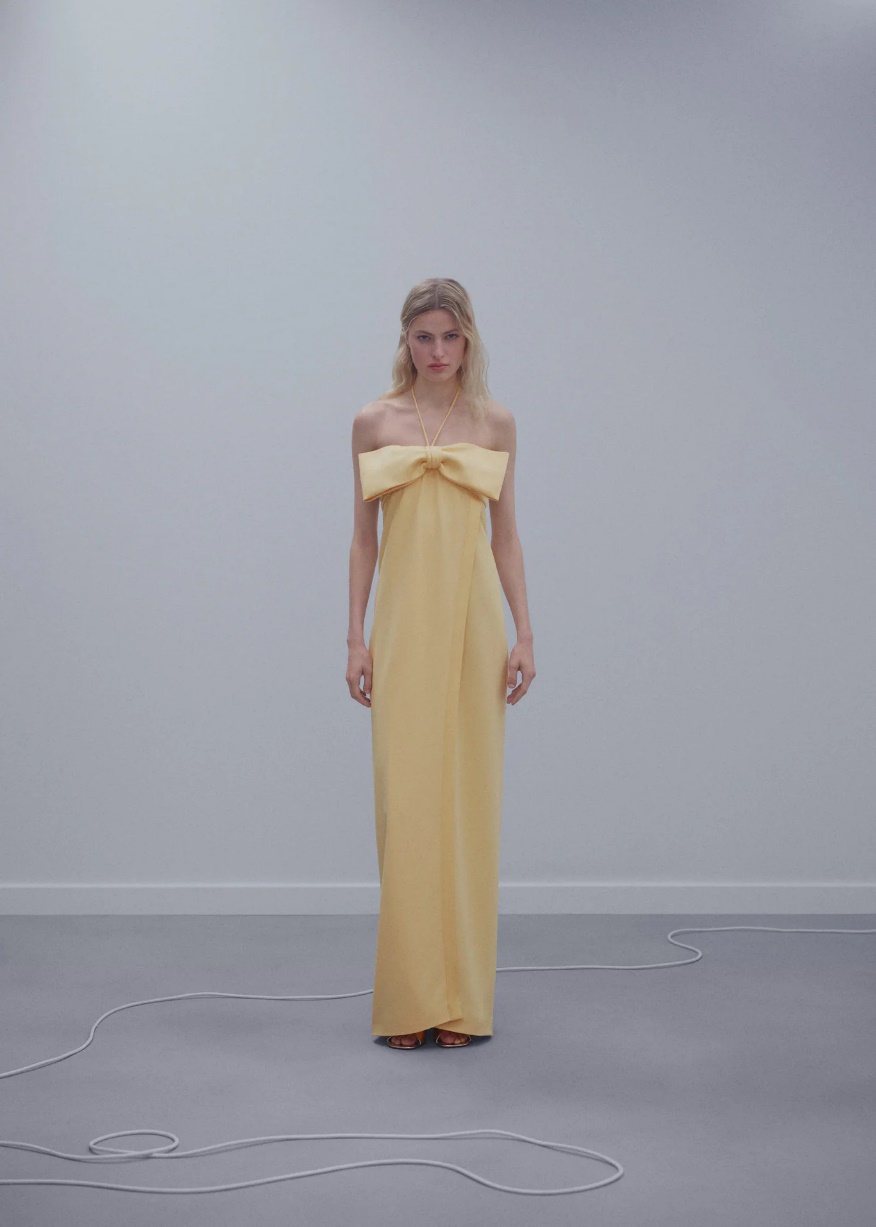 A person in a yellow dress Description automatically generated