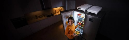 a girl with a fridge open in the night