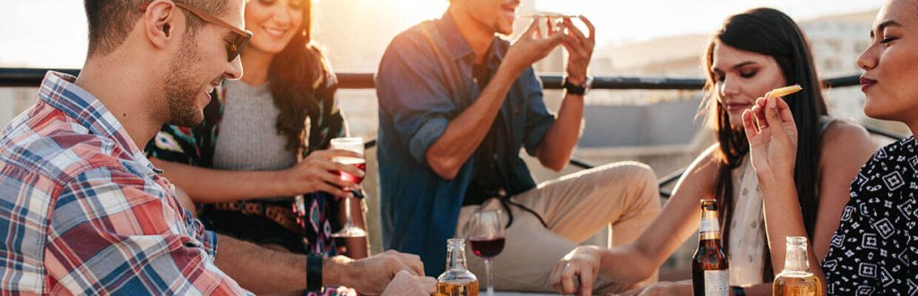 Friends enjoying drinks and snacks on a sunny rooftop terrace