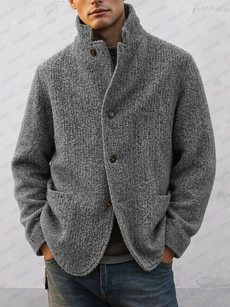 Man in a grey herringbone coat with stand-up collar