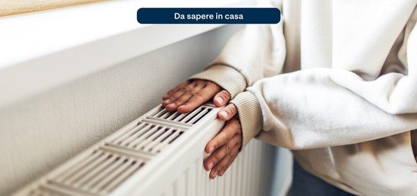 Hands resting on a warm radiator in a home