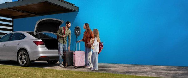 Family loading a car boot beside a home charging point, from the A2A Wallbox page