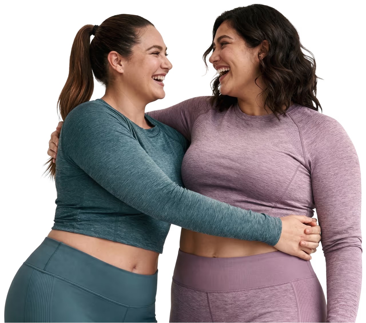 Two women in activewear smiling and hugging after a workout
