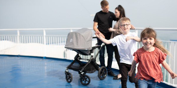 A family with a pushchair on the open deck of a DFDS ferry