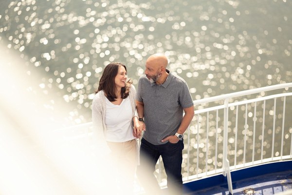 A couple smiling on the deck of a DFDS ferry in the sunshine