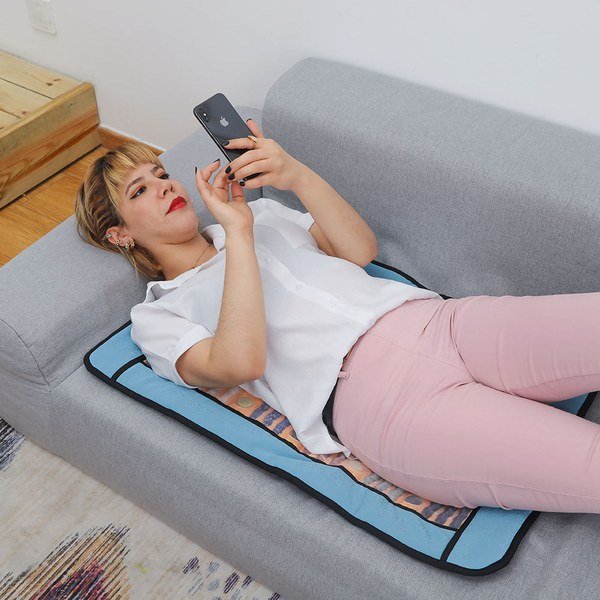 PHYMAT Far Infrared Chakra 7-Gems Rainbow Mat with a blue border used on a sofa
