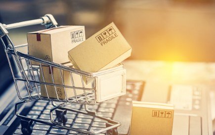 Shopping trolley filled with parcels in front of a sunset
