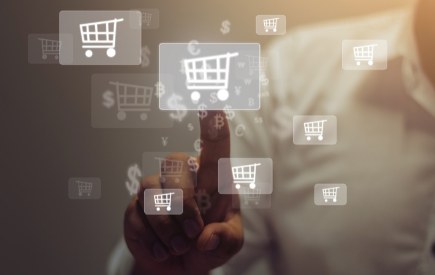 Hand touching a screen with online shopping cart icons