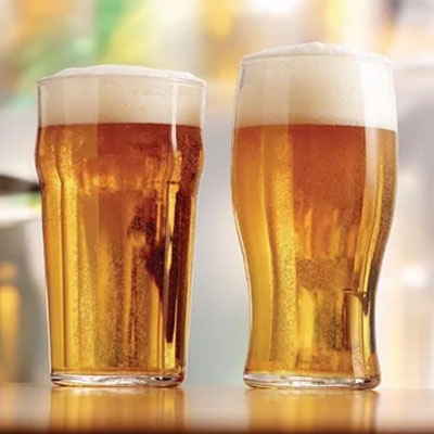 Two pint glasses of cold beer on a bar counter