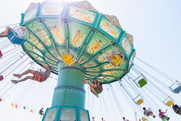 Los Icaros swing ride spinning against a blue sky