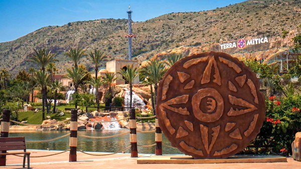 Terra Mitica park landscape with themed buildings and mountains behind