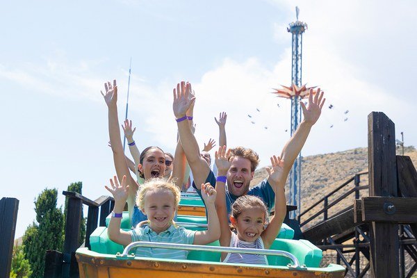 Riders raising their arms on the Alucinakis ride at Terra Mitica