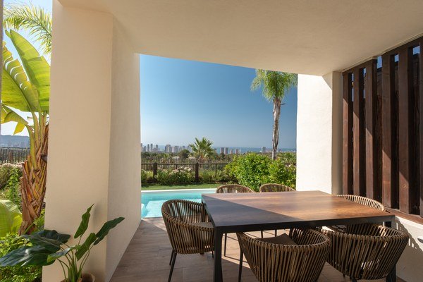 Villa room opening onto a terrace with a pool view